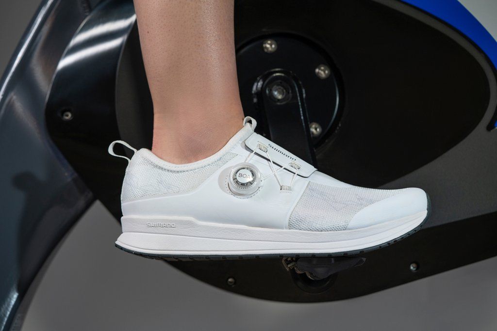 Women wearing a pair of white Shimano IC300 Indoor Cycling shoe while riding a Stages bike